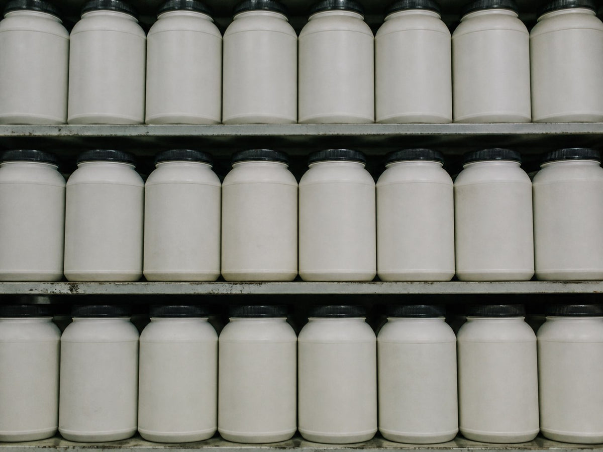 Supplement tubs on a shelf, labels facing out